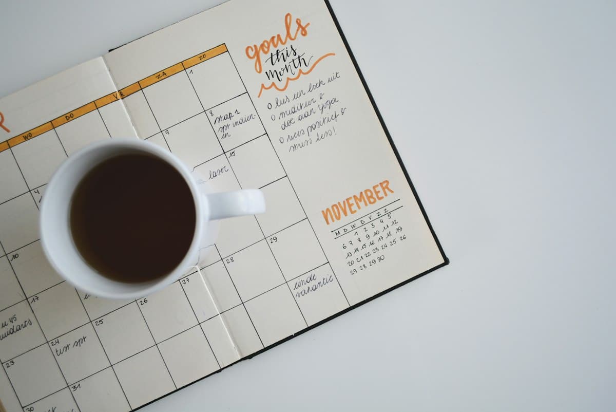 A coffee cup on an open monthly planner